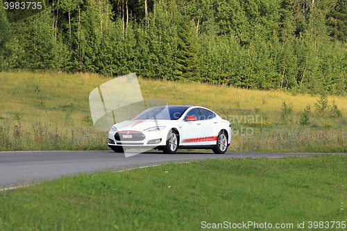 Image of Tesla Model S Electric Car and Green Rural Road