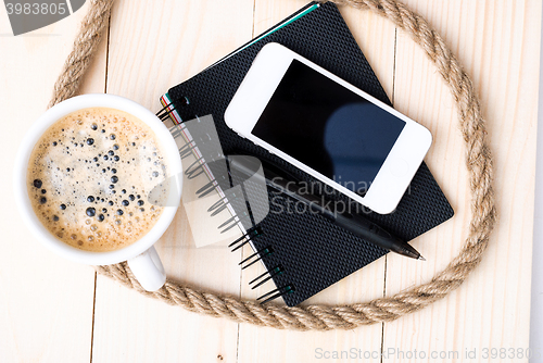 Image of Smartphone with notebook and cup of strong coffee