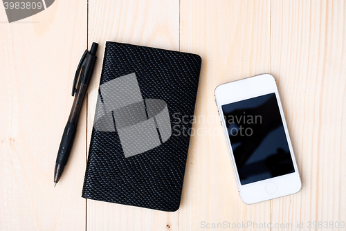 Image of Small notepad with pen and smartphone