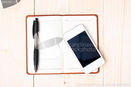 Image of Small notepad with pen and smartphone