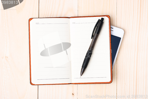 Image of Small notepad with pen and smartphone