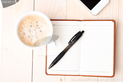 Image of Smartphone with notebook and cup of strong coffee