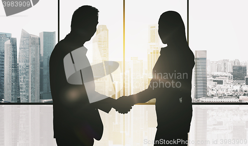 Image of business partners silhouettes making handshake