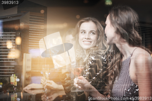 Image of happy women with drinks at night club