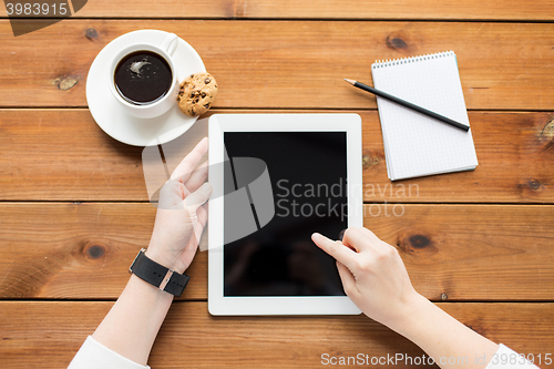 Image of close up of woman with tablet pc on wooden table