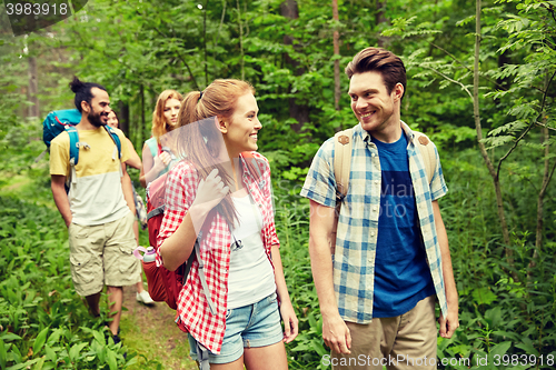 Image of group of smiling friends with backpacks hiking