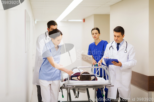 Image of medics with woman on hospital gurney at emergency