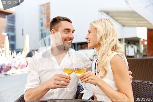 Image of happy couple drinking wine at open-air restaurant