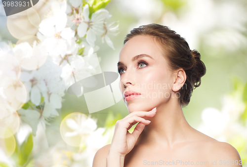 Image of beautiful young woman touching her face