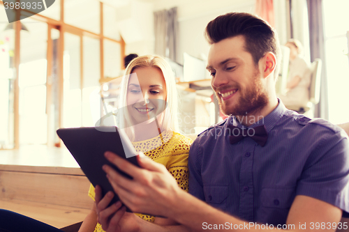 Image of happy creative team with tablet pc in office