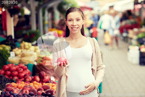 Image of pregnant woman choosing food at street market