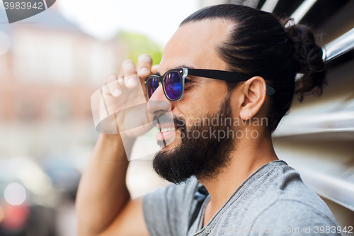Image of happy smiling man with beard on city street