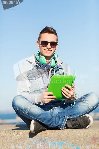 Image of happy young man with tablet pc and headphones
