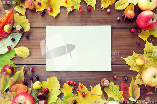 Image of close up of paper with autumn leaves and fruits