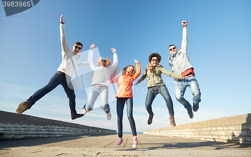 Image of smiling friends in sunglasses laughing on street