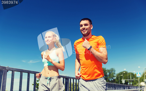 Image of smiling couple running at summer seaside