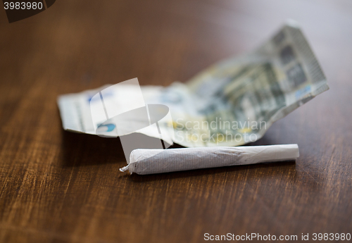 Image of close up of marijuana joint and money