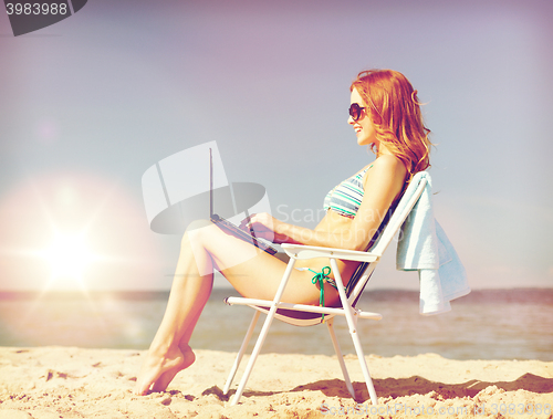 Image of girl looking at tablet pc on the beach