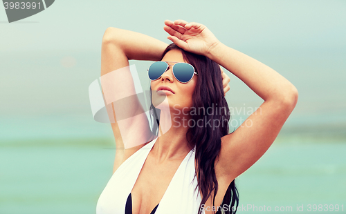 Image of young woman with sunglasses on beach