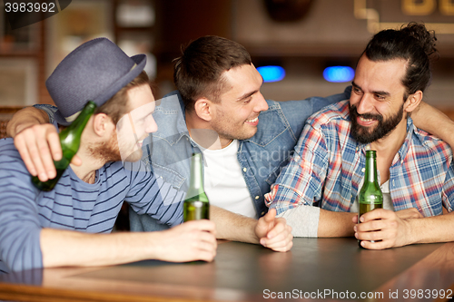 Image of happy male friends drinking beer at bar or pub