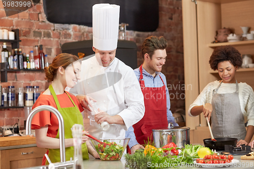 Image of happy friends and chef cook cooking in kitchen