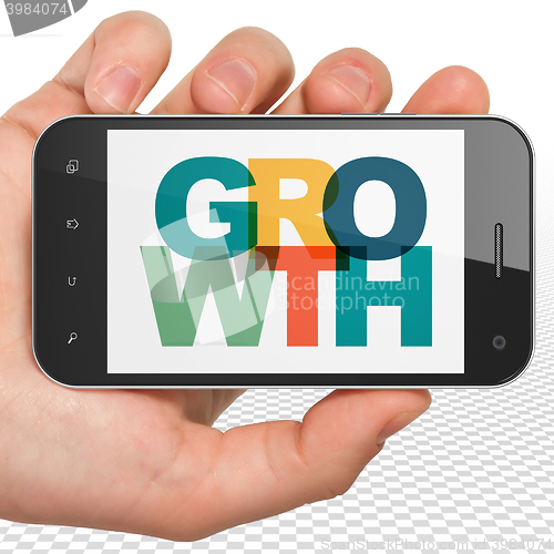 Image of Business concept: Hand Holding Smartphone with Growth on  display