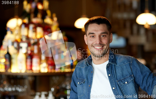 Image of happy smiling young man at bar or pub