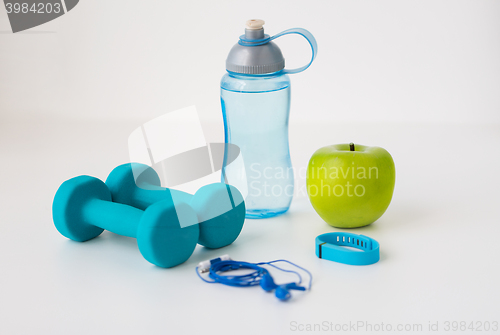 Image of dumbbells, fitness tracker, earphones and bottle