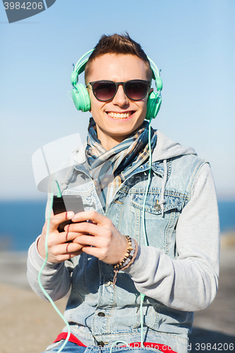 Image of happy young man in headphones with smartphone