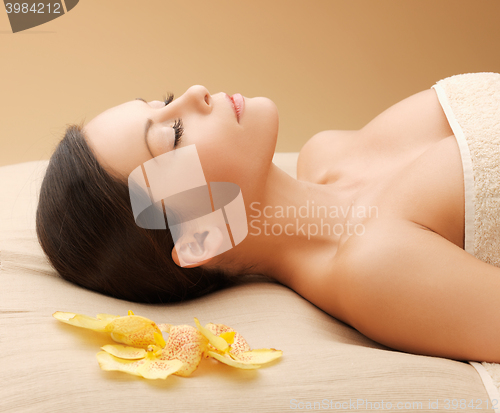 Image of woman in spa salon lying on the massage desk