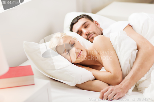 Image of happy couple sleeping in bed at home