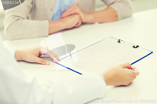 Image of close up of senior woman and doctor with clipboard