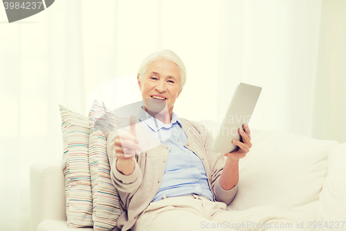 Image of senior woman with tablet pc showing thumbs up 