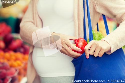 Image of pregnant woman buying food at street market