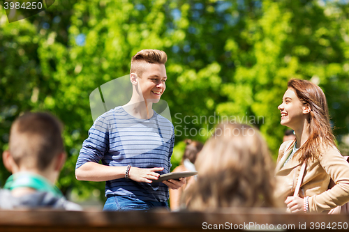 Image of group of teenage students with tablet pc outoors