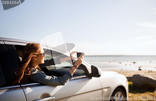 Image of happy teenage girl or young woman in car