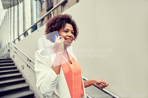 Image of happy african businesswoman calling on smartphone