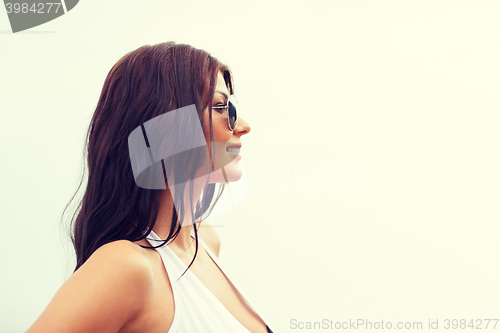 Image of smiling young woman with sunglasses on beach