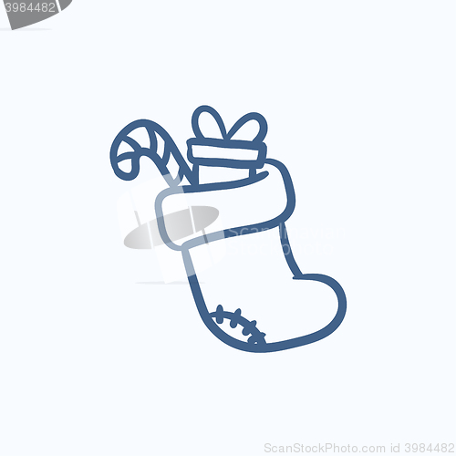 Image of Christmas boot with gift and candy sketch icon.