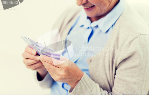 Image of close up of happy senior woman playing cards