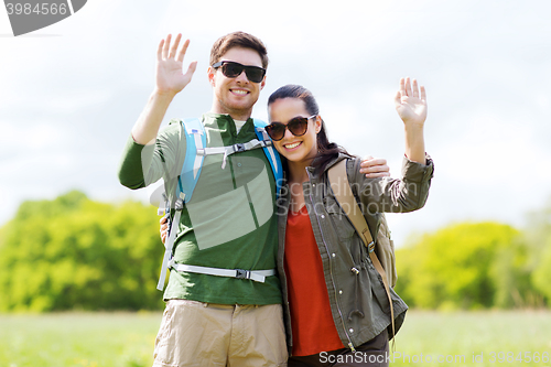 Image of happy couple with backpacks hiking outdoors