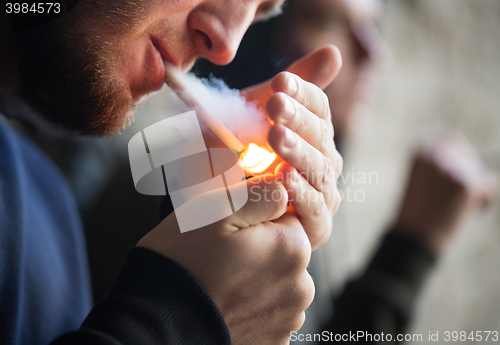 Image of close up of young people smoking cigarette