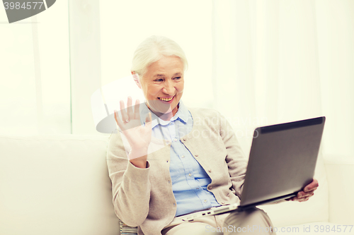Image of senior woman with laptop having video chat at home