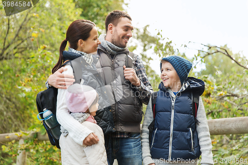 Image of happy family with backpacks hiking