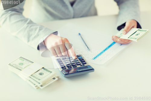 Image of close up of hands counting money with calculator