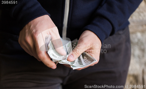 Image of close up of addict or drug dealer hands with money