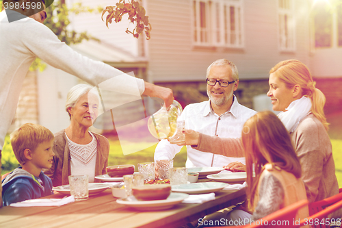 Image of happy family having holiday dinner outdoors