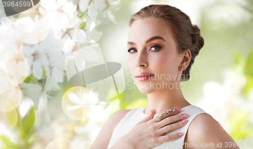 Image of smiling woman in white dress with diamond jewelry