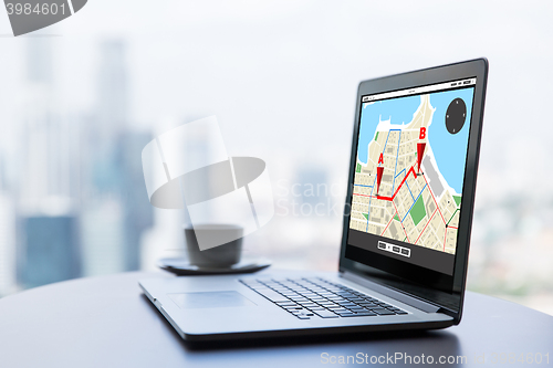 Image of close up of laptop and coffee cup on office table