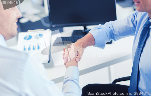 Image of businessmen shaking hands in office